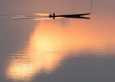 a lake reflecting the warm light of the sun, with a canoe
